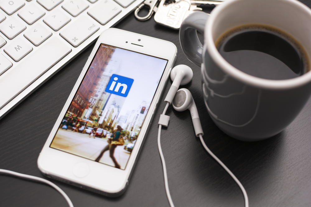 LinkedIn app on phone on desk with coffee
