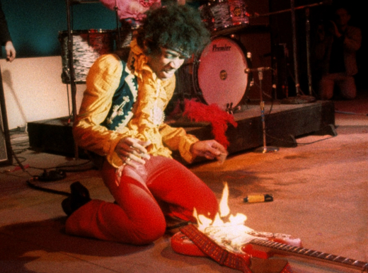 Jimi Hendrix burning his guitar on stage at Monterey Pop Festival.