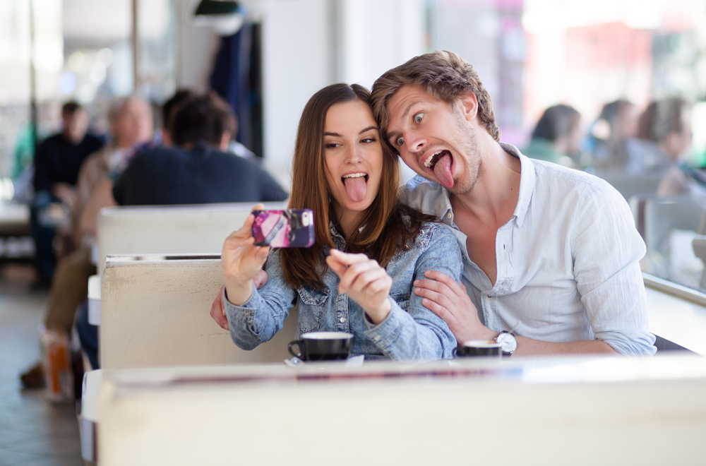 A young couple taking a selfie in a diner.