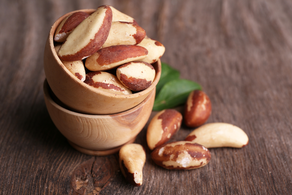 Tasty brasil nuts on wooden background.