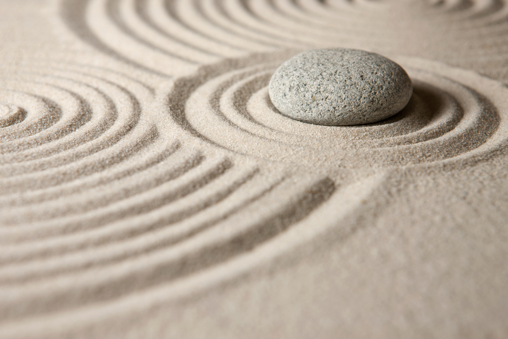 A zen garden with a rock and sand..