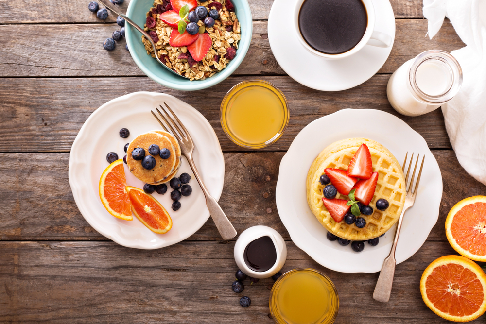 Breakfast table with waffles, granola and fresh berries