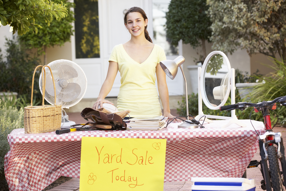 A young girl having a yard sale.