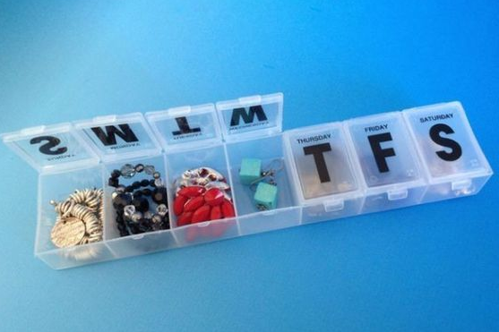 A pill box organizing jewelry. 