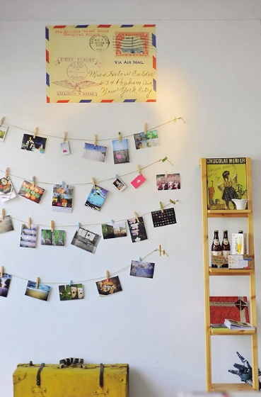 Photo postcard on the wall with strung up photos.