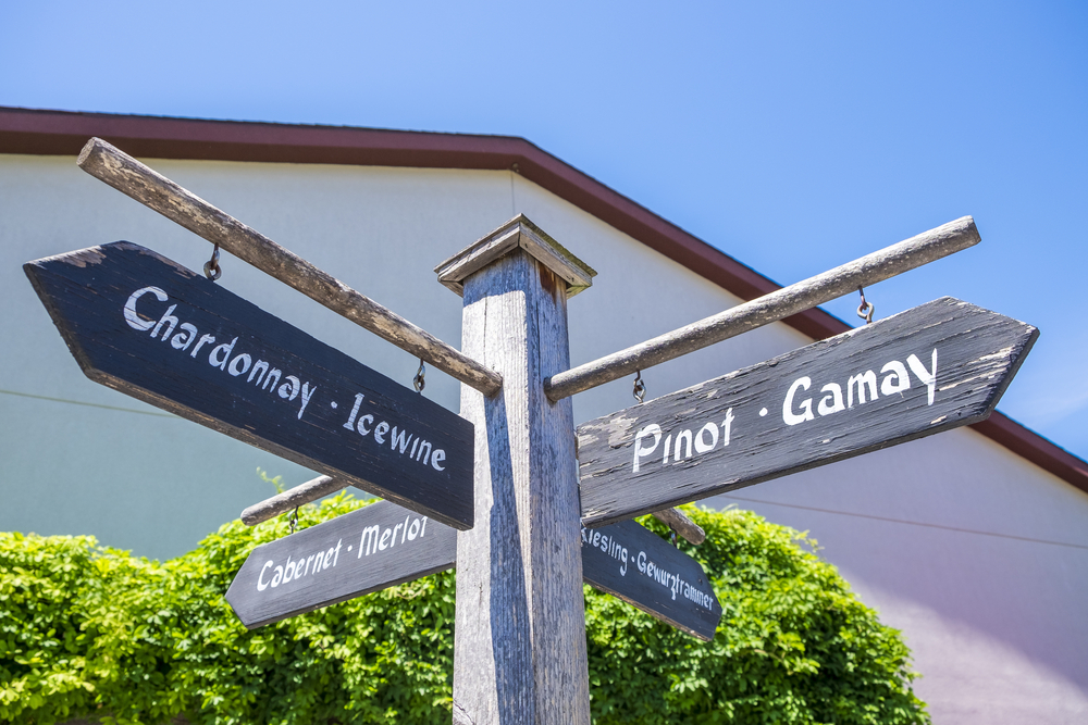 Signs on a post point the direction to various wines at a vineyard in Niagara on the Lake in Ontario Canada.