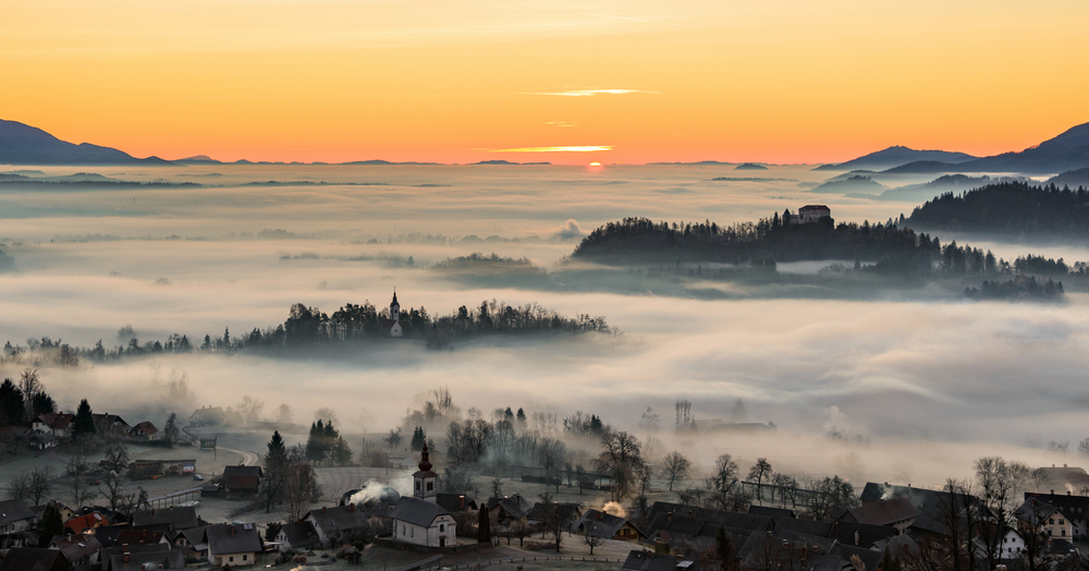 A misty morning landscape photo over a countryside.
