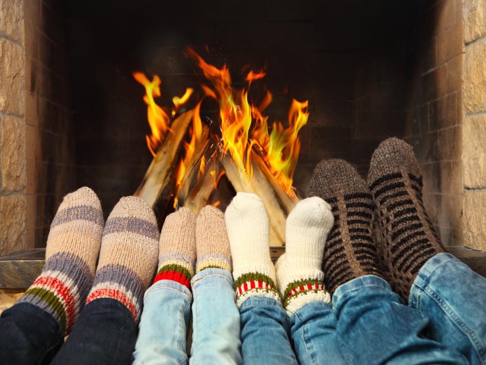 Family cuddled up by fire