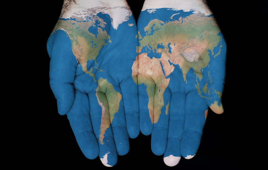 Map painted on hands showing concept of having The World in our hands