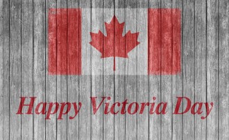 A Happy Victoria day sign on a dock with a Canadian flag.