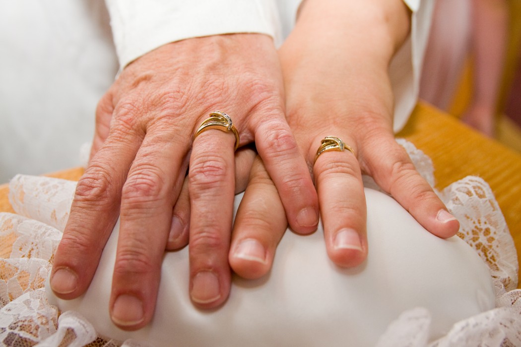 An older couple's hands with their rings.