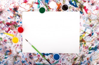 A blank canvas with colourful paint surrounding it.