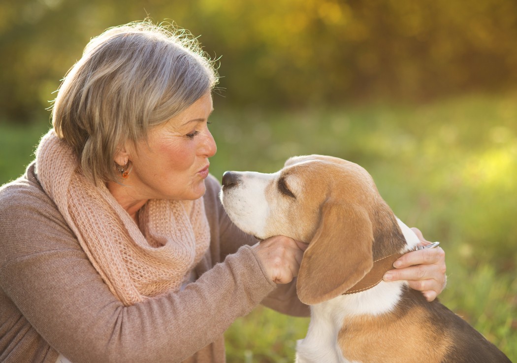 A woman hugging her beagle dog.