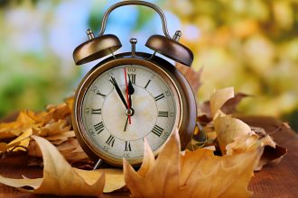 An alarm clock and fall leaves.
