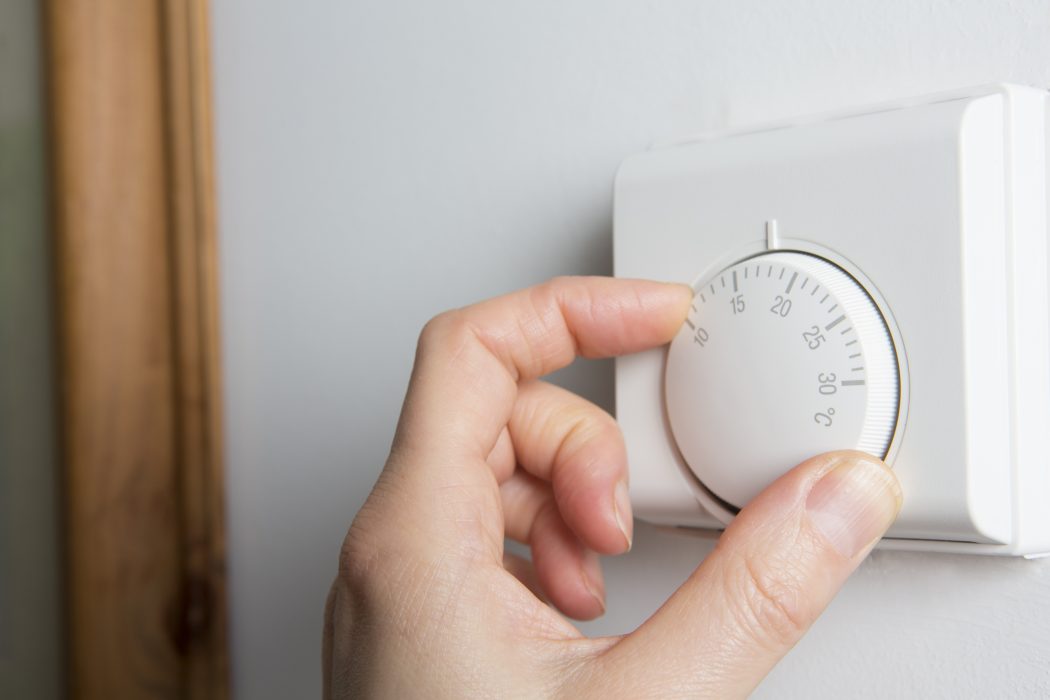 A woman's hand on a thermostat