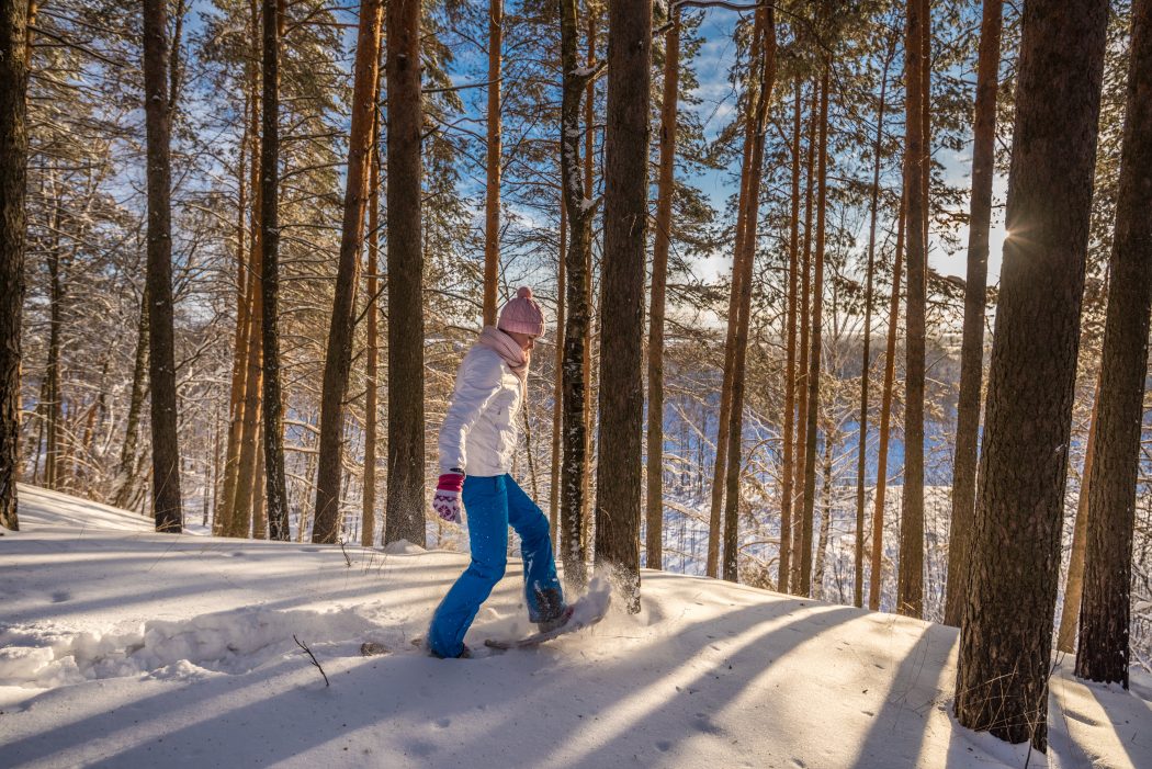 Woman in a forest snowshoeing